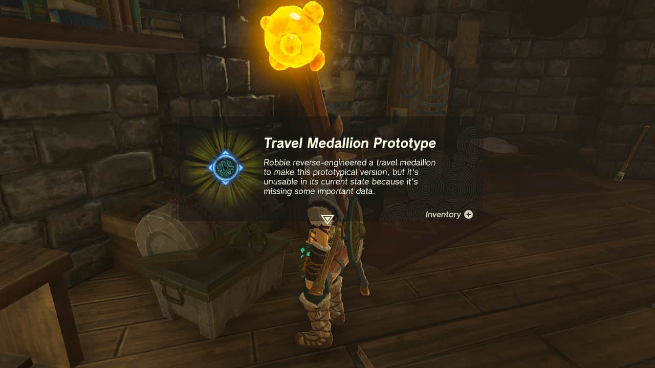 Tears of the Kingdom Travel Medallion: Link finding the Travel Medallion Prototype in a chest. The text reads: "Robbie reverse-engineered a travel medallion to make this prototypical version, but it's unusable in its current state because it's missing some important data."