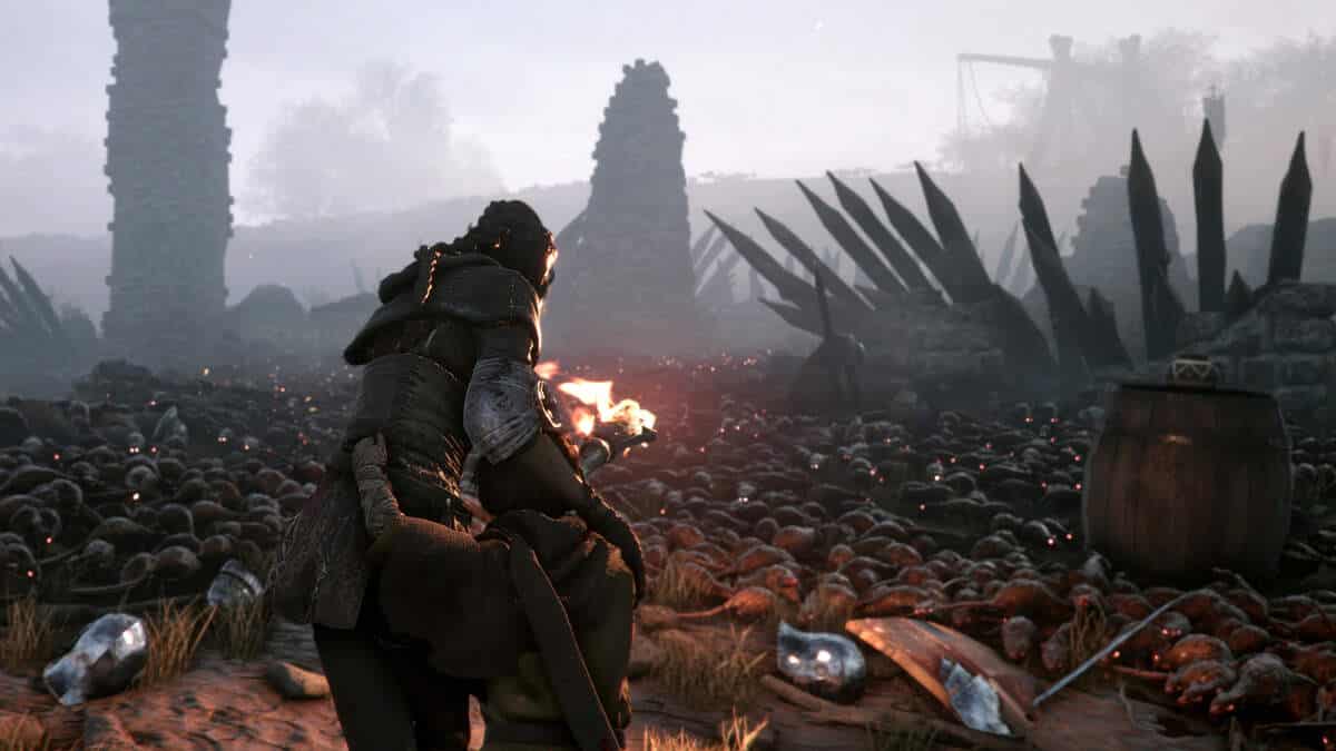 A person with a torch navigates through a horde of rats in A Plague Tale: Innocence.