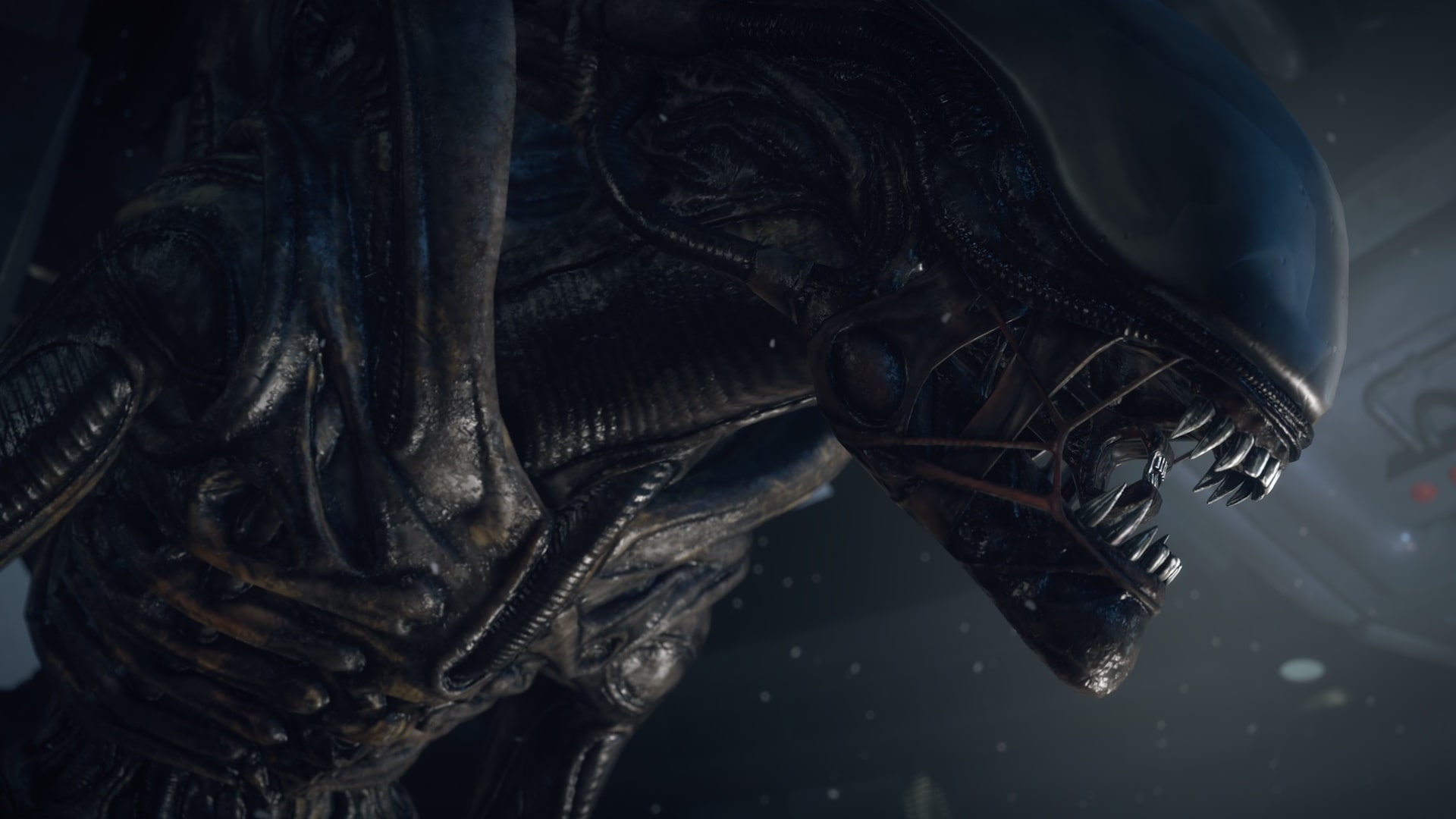 A terrifying close up of the xenomorph’s snarling face in Alien Isolation, showing its sharp metallic teeth and dark biomechanical skin.