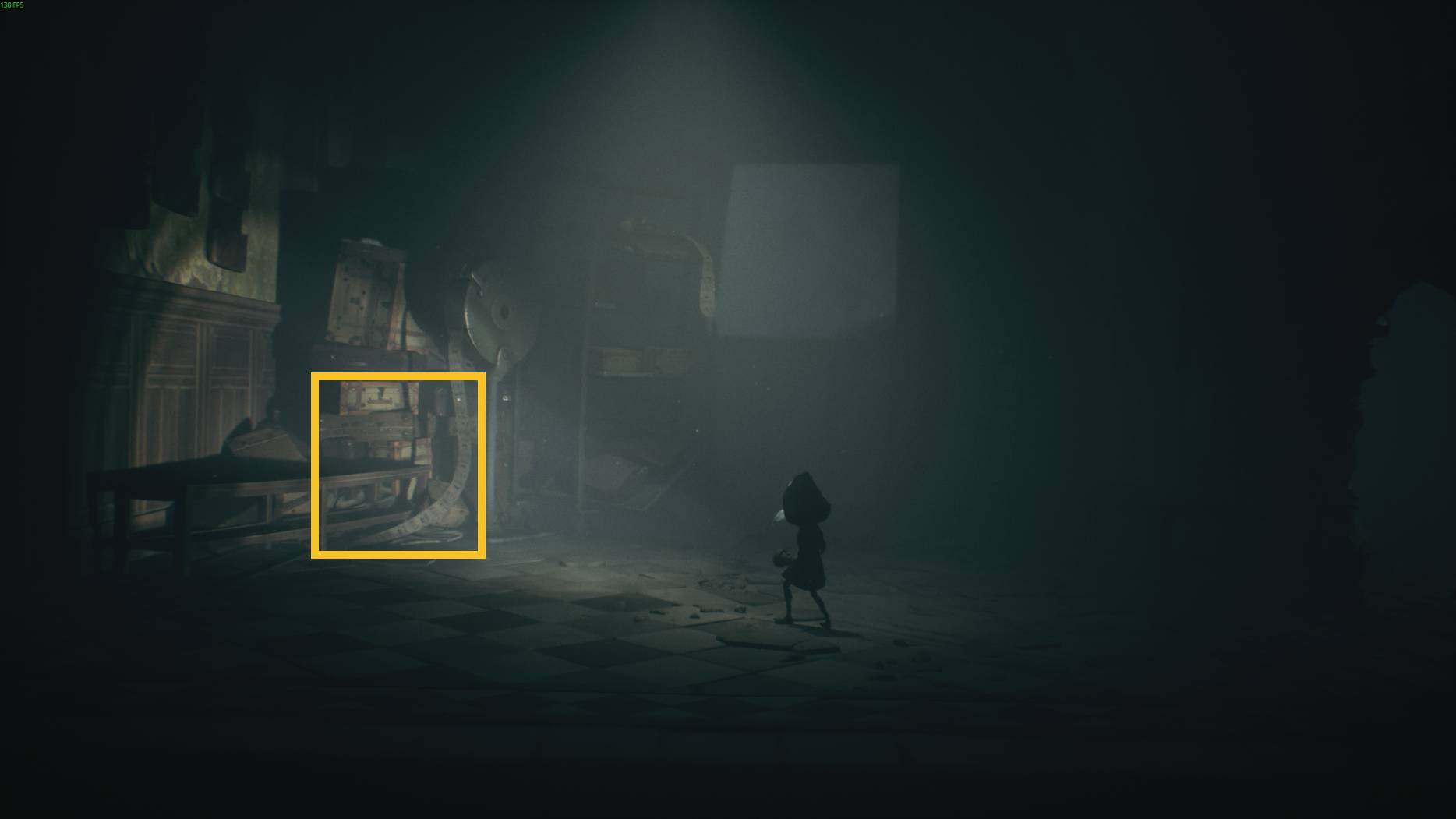 The player explores a dimly lit puzzle room in All Little Nightmares 3 with measuring tapes and strange machinery scattered across the floor.