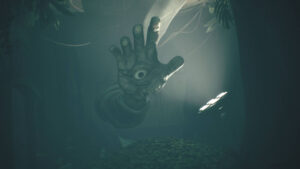 A giant eerie hand with an eye in its palm reaches through the darkness in All Little Nightmares 3