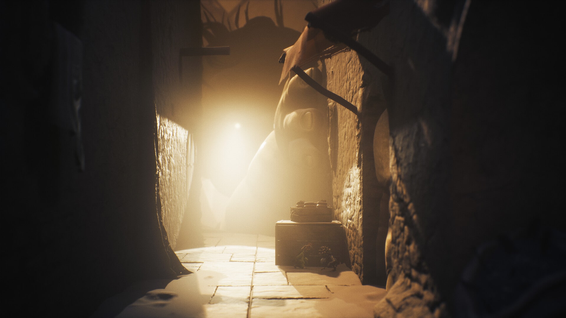 A dark, eerie corridor with dim lighting and a mysterious, bent giant hand at the end