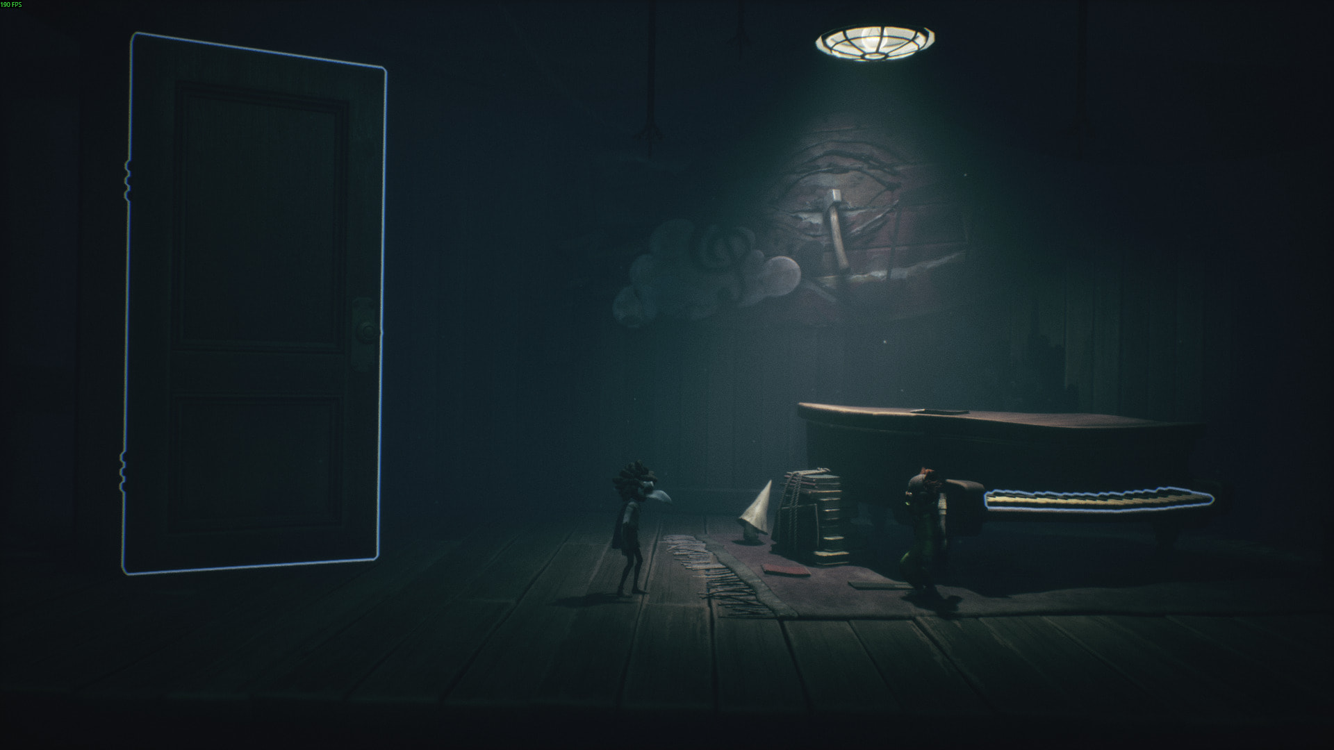 Two small characters in Little Nightmares 3 explore a dark room, with one pushing a piano under a hanging light while the other watches near a glowing door
