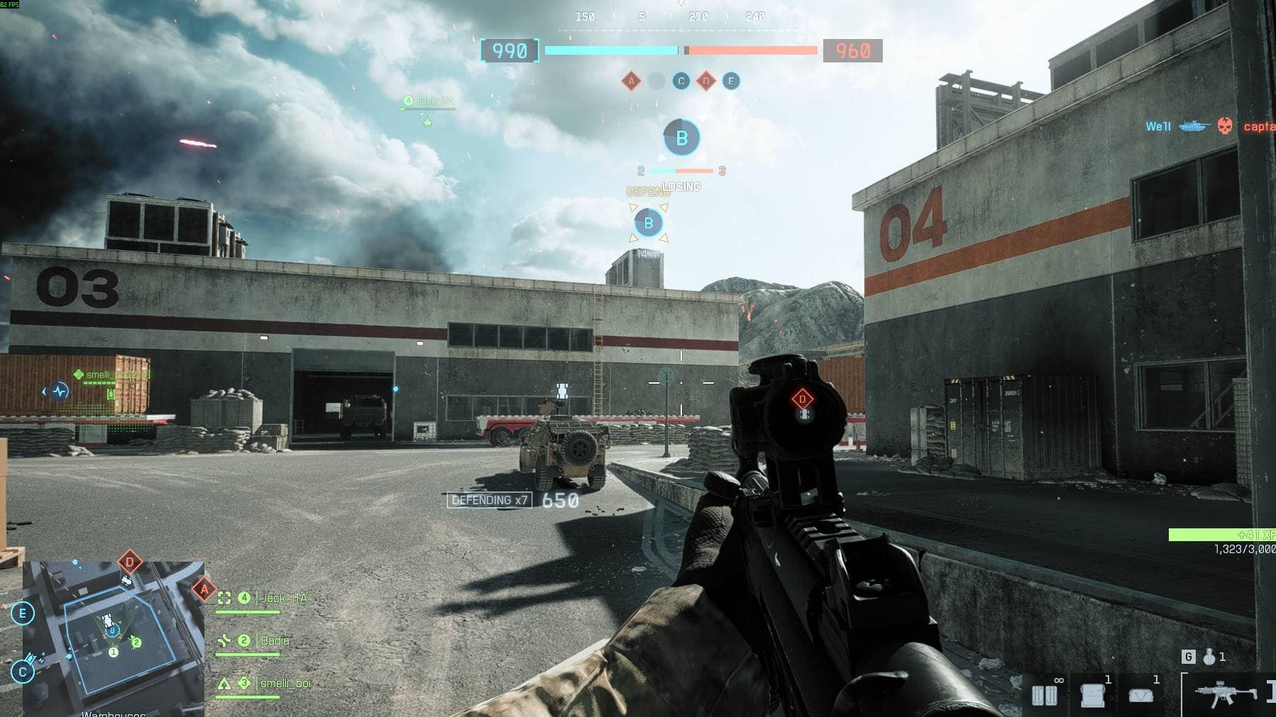 Player aims down sights while defending objective B on a large industrial map in Battlefield 6 multiplayer