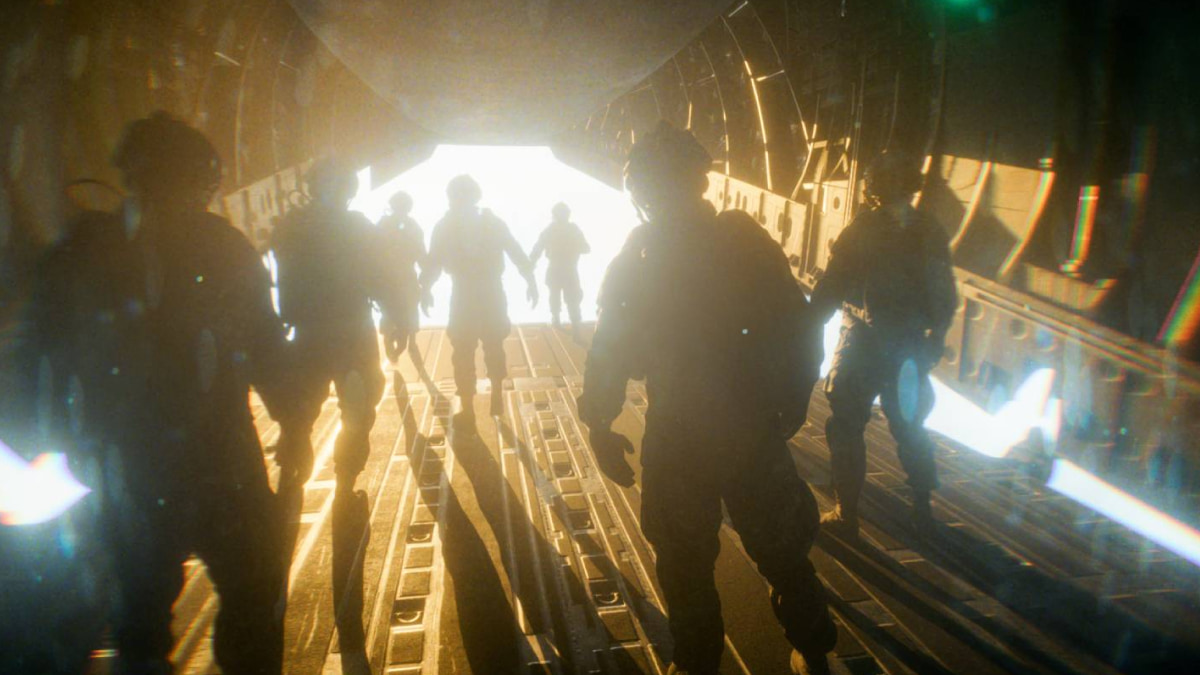 The silhouettes of soldiers in Battlefield 6 stand inside a dimly lit aircraft, preparing to jump