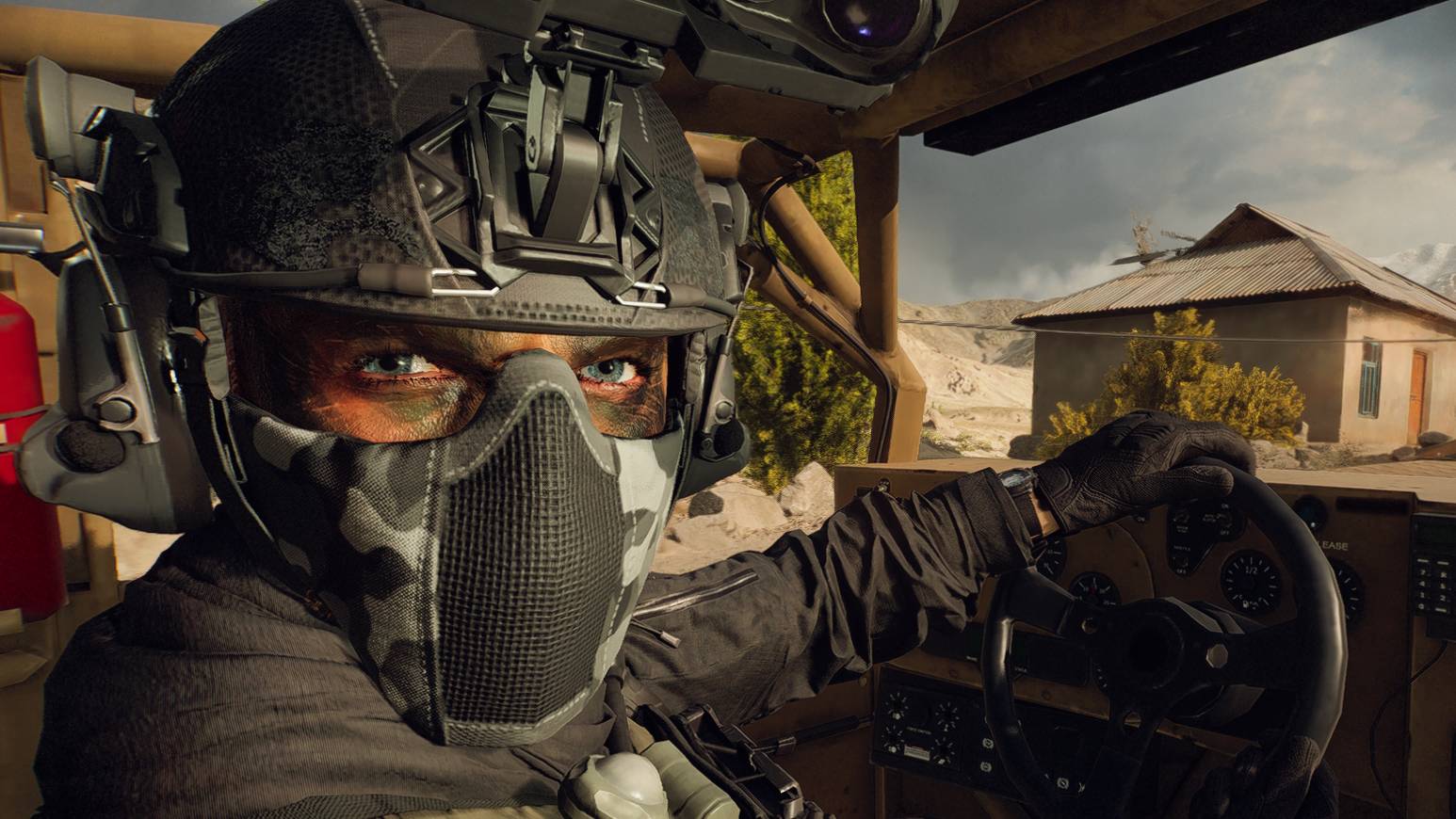 A soldier in a camo mask and helmet, driving a military vehicle