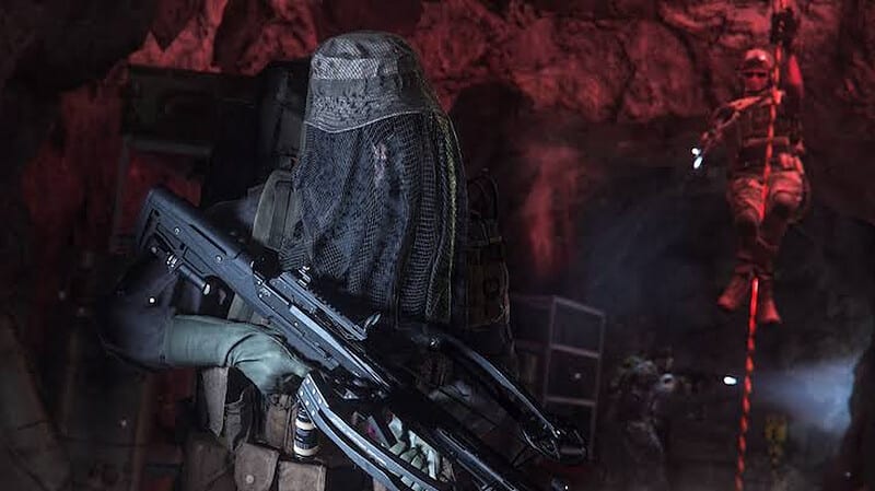 A man armed with a MW2 Crossbow takes cover in a cave.