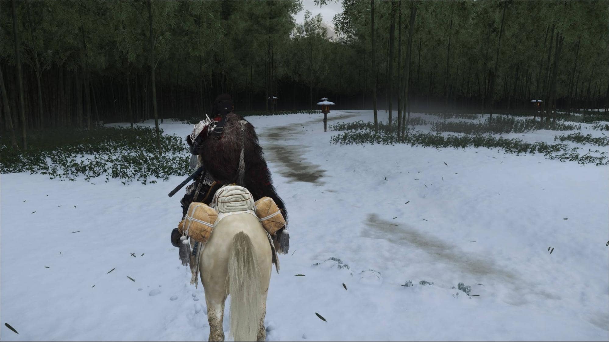 Ghost of Yotei character on horseback travels through a snow-covered bamboo forest
