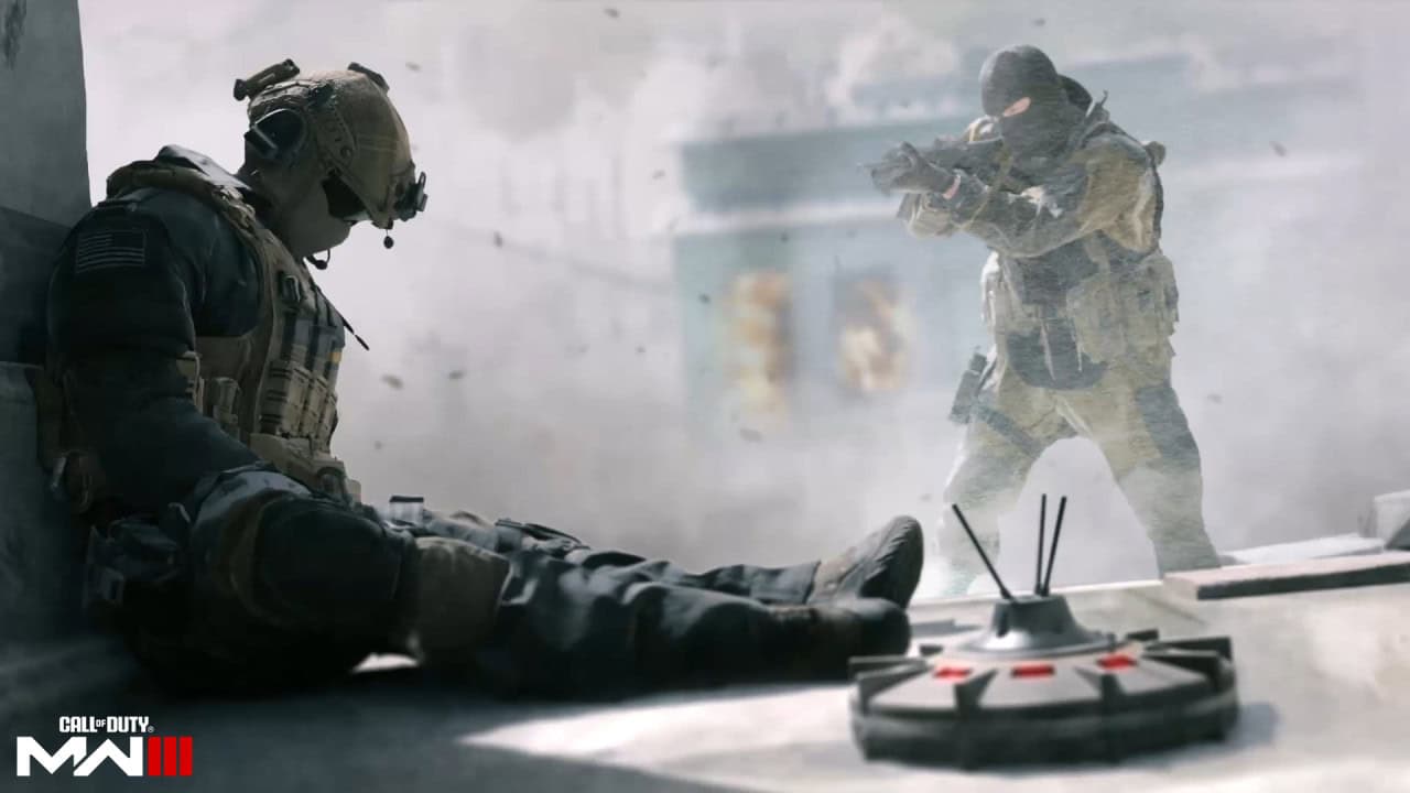 Two soldiers in Call of Duty Modern Warfare 3 combat gear, one crouching and looking on while the other aims a rifle, with a detonator on the ground before them.
