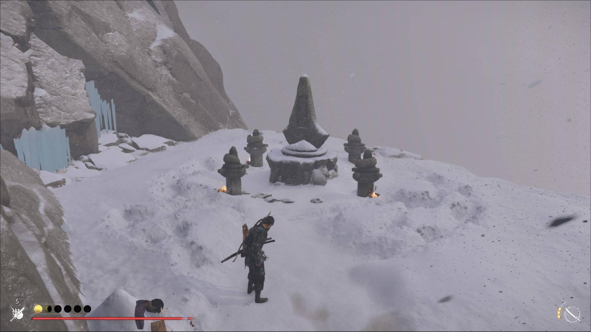 A lone warrior stands on a snowy mountain ledge, facing a stone shrine surrounded by small lanterns Ghost of Yotei