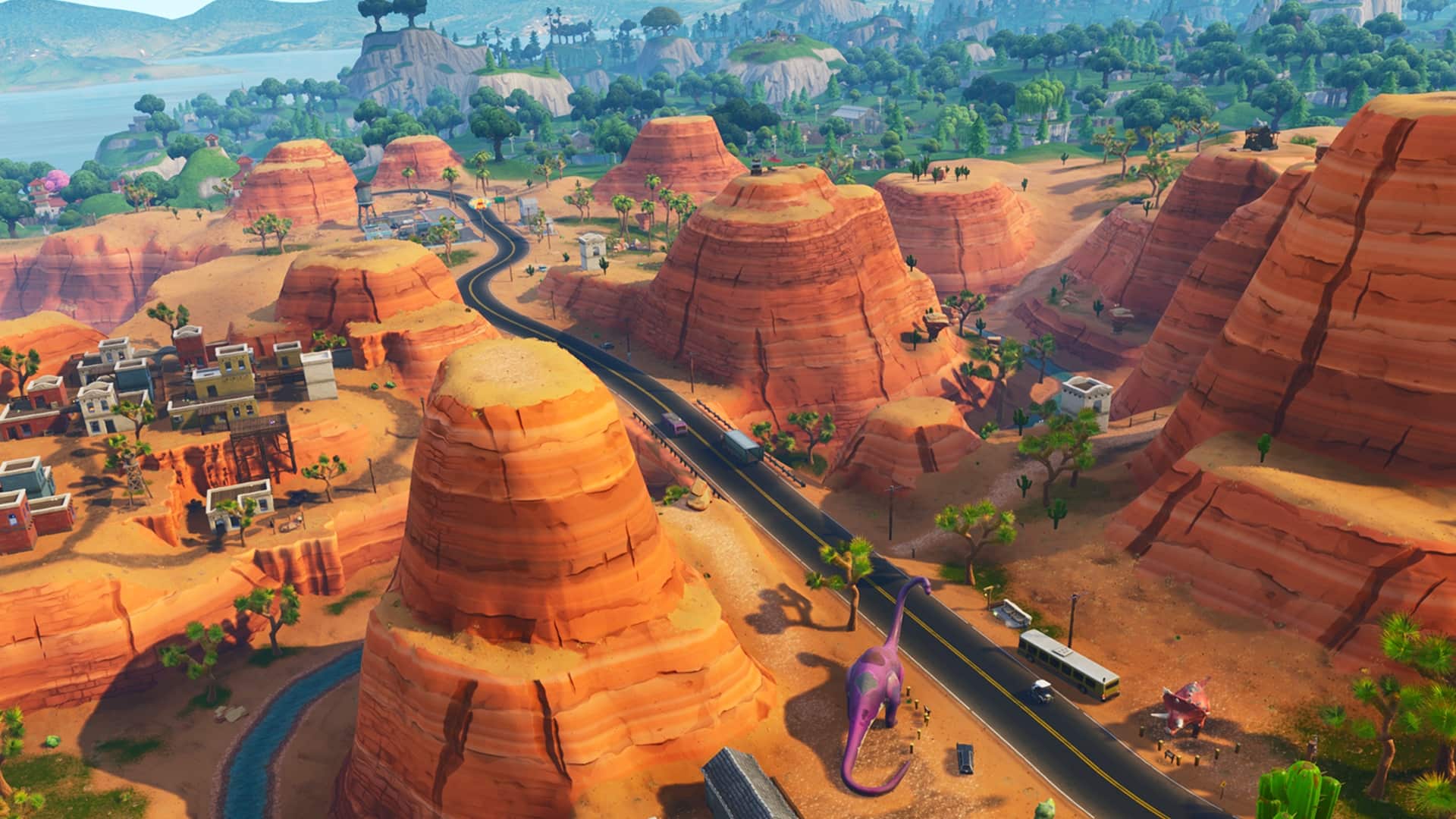 Fortnite desert map with red canyons, winding road, and scattered buildings