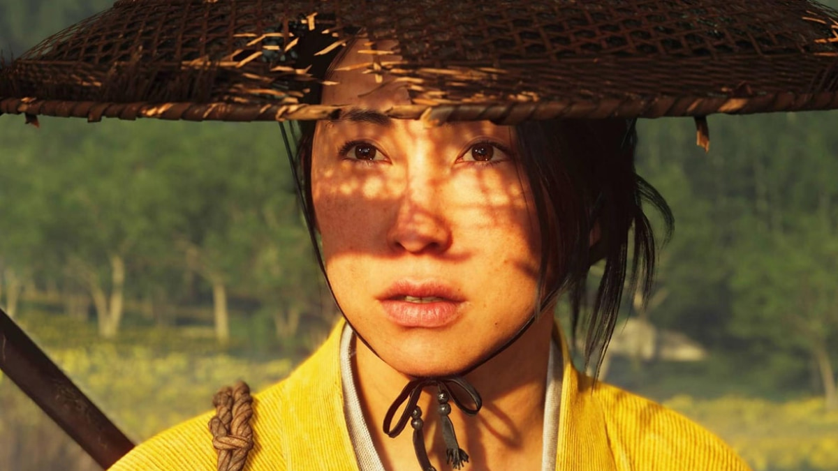 Close-up of a character in Ghost of Yotei wearing a straw hat, with sunlight casting patterned shadows across her face