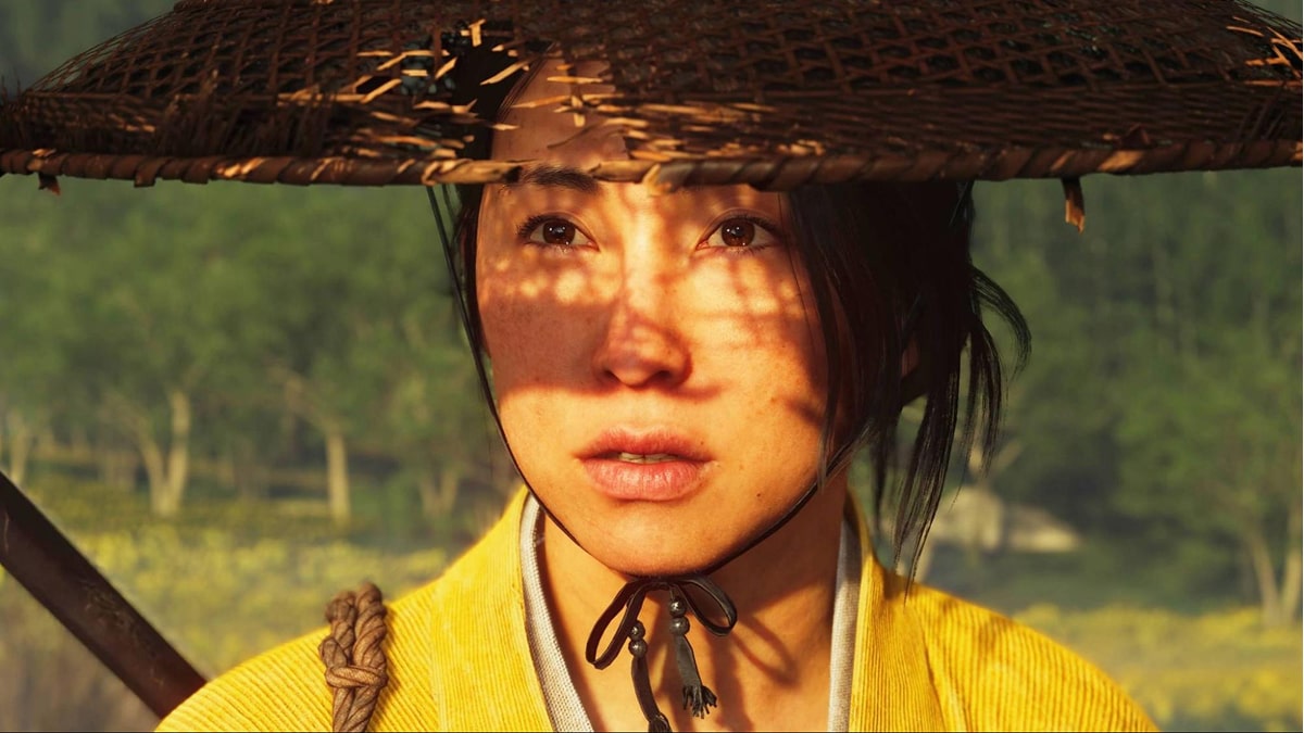 Close-up of a character in Ghost of Yotei wearing a straw hat, with sunlight casting patterned shadows across her face