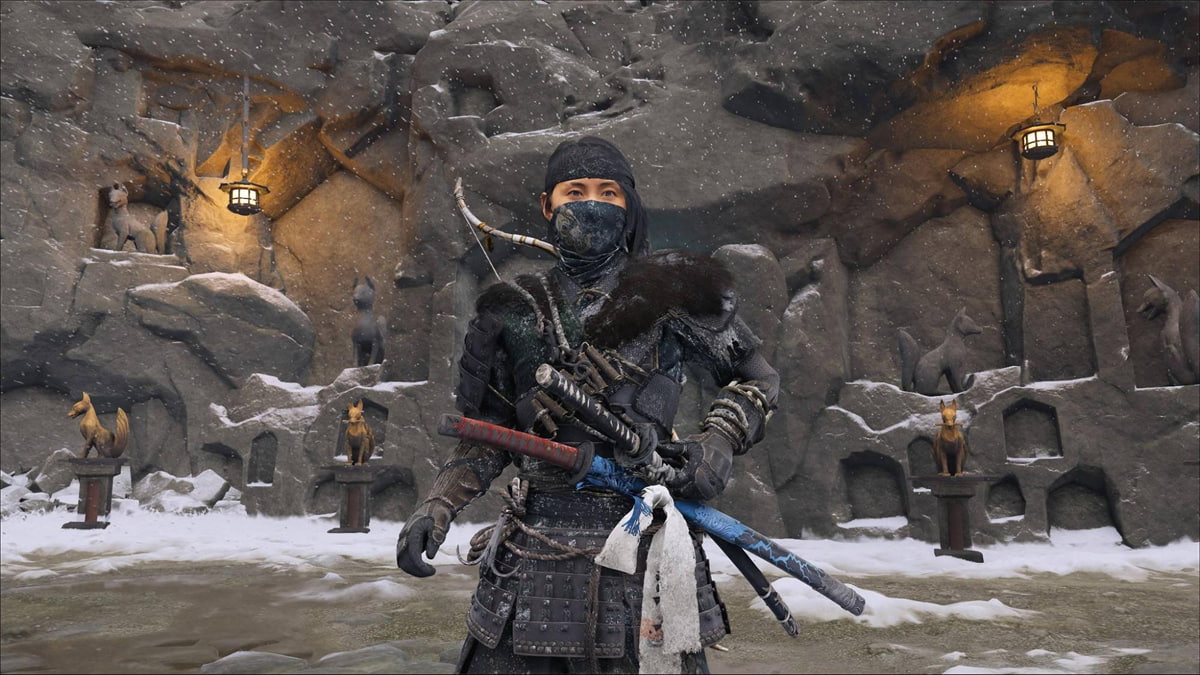 Warrior standing before fox statues in a snowy shrine from Ghost of Yotei