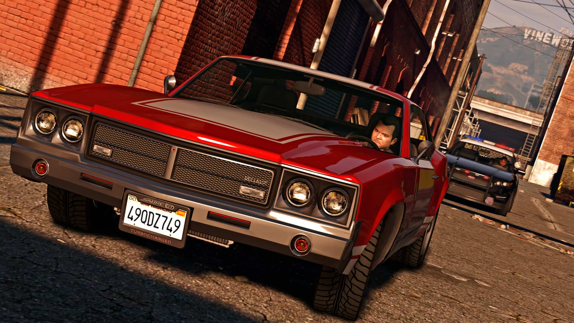 Michael evading police in a red muscle car during a pursuit in Grand Theft Auto 5