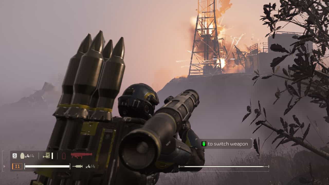 First-person view in a video game showing a character holding an airburst rocket launcher, aiming at a distant flaming structure in a foggy, twilight environment.