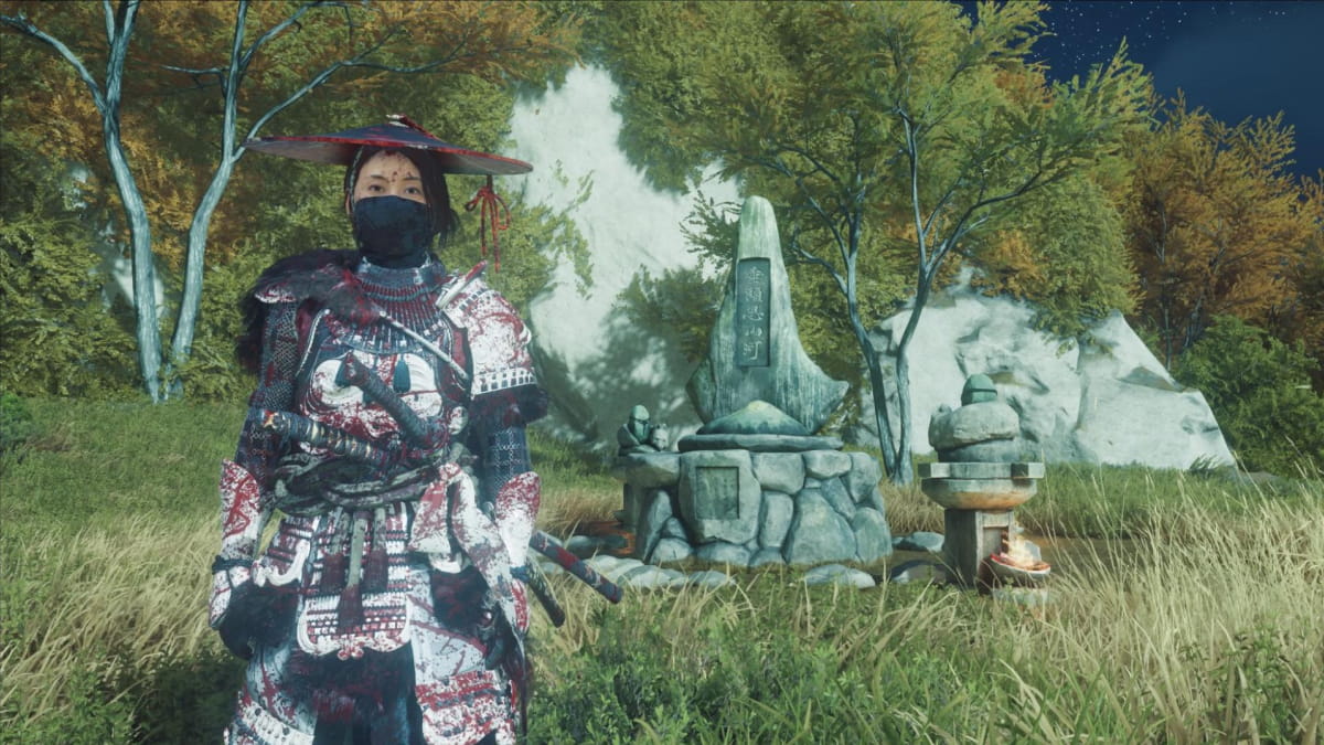 Ghost of Yotei character in detailed samurai armor stands solemnly in a grassy meadow beside a stone shrine, under a starlit sky