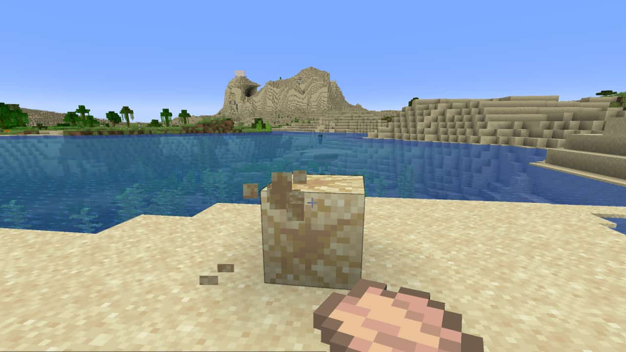 How to use a brush in Minecraft: A player using a brush to excavate a block of suspicious sand.