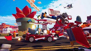 Is Lego 2K Drive on PS4 or Xbox One: A Lego race car smashes through a chaotic mess of lego bricks on the race track.