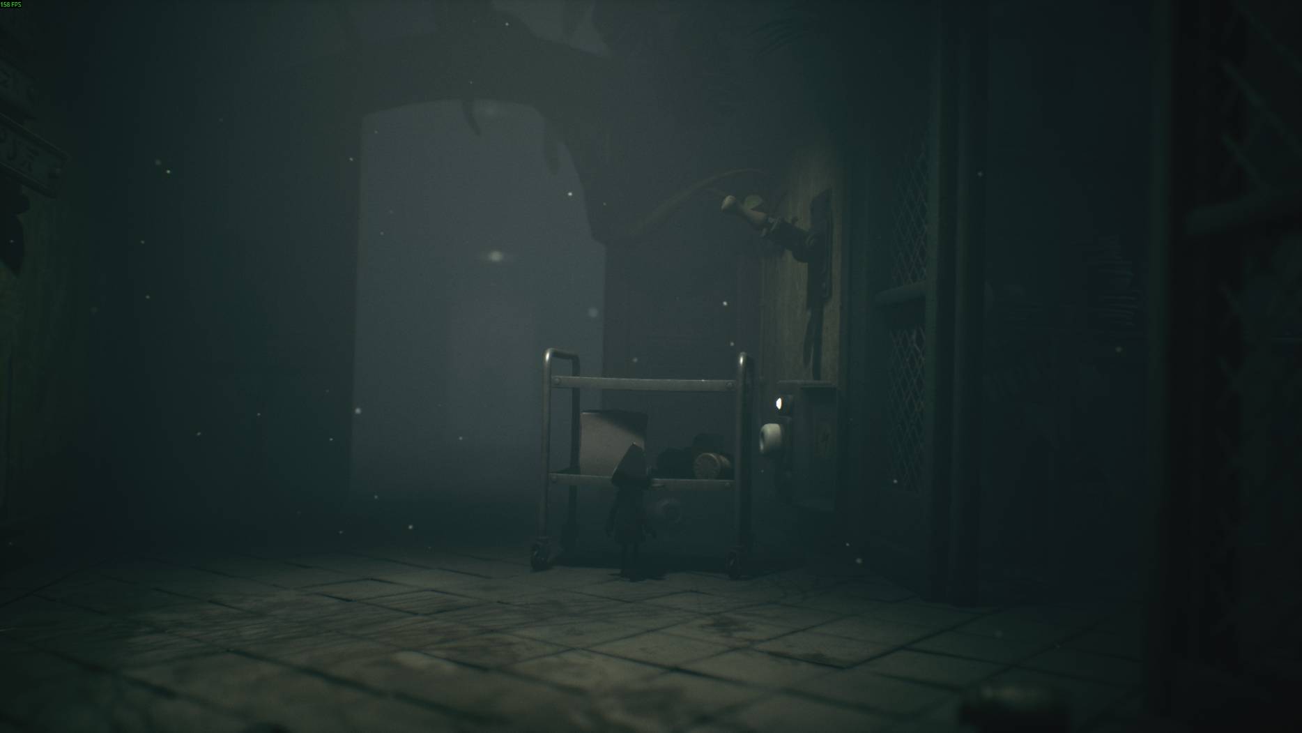 Dark corridor in Little Nightmares 3 with a small cart blocking the path