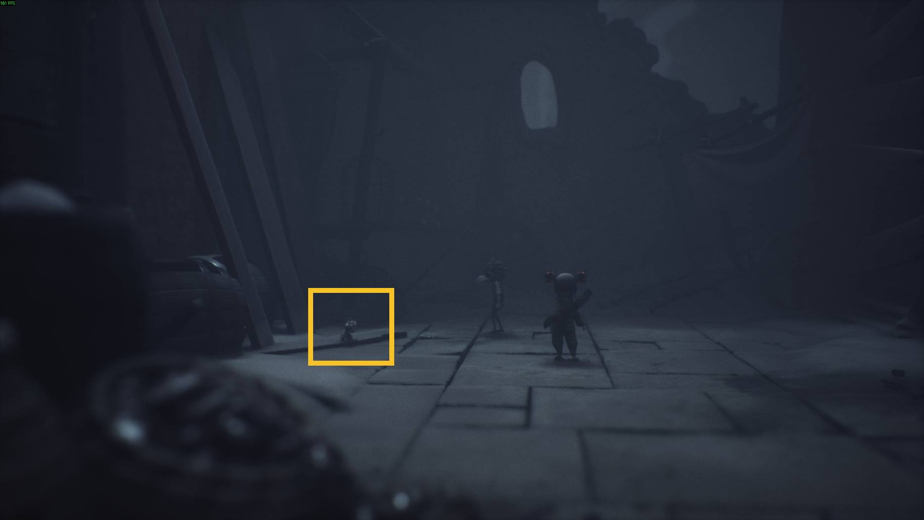 Two small characters wander through dark ruins in Little Nightmares 3, noticing a tiny figure crouched on the cracked stone floor