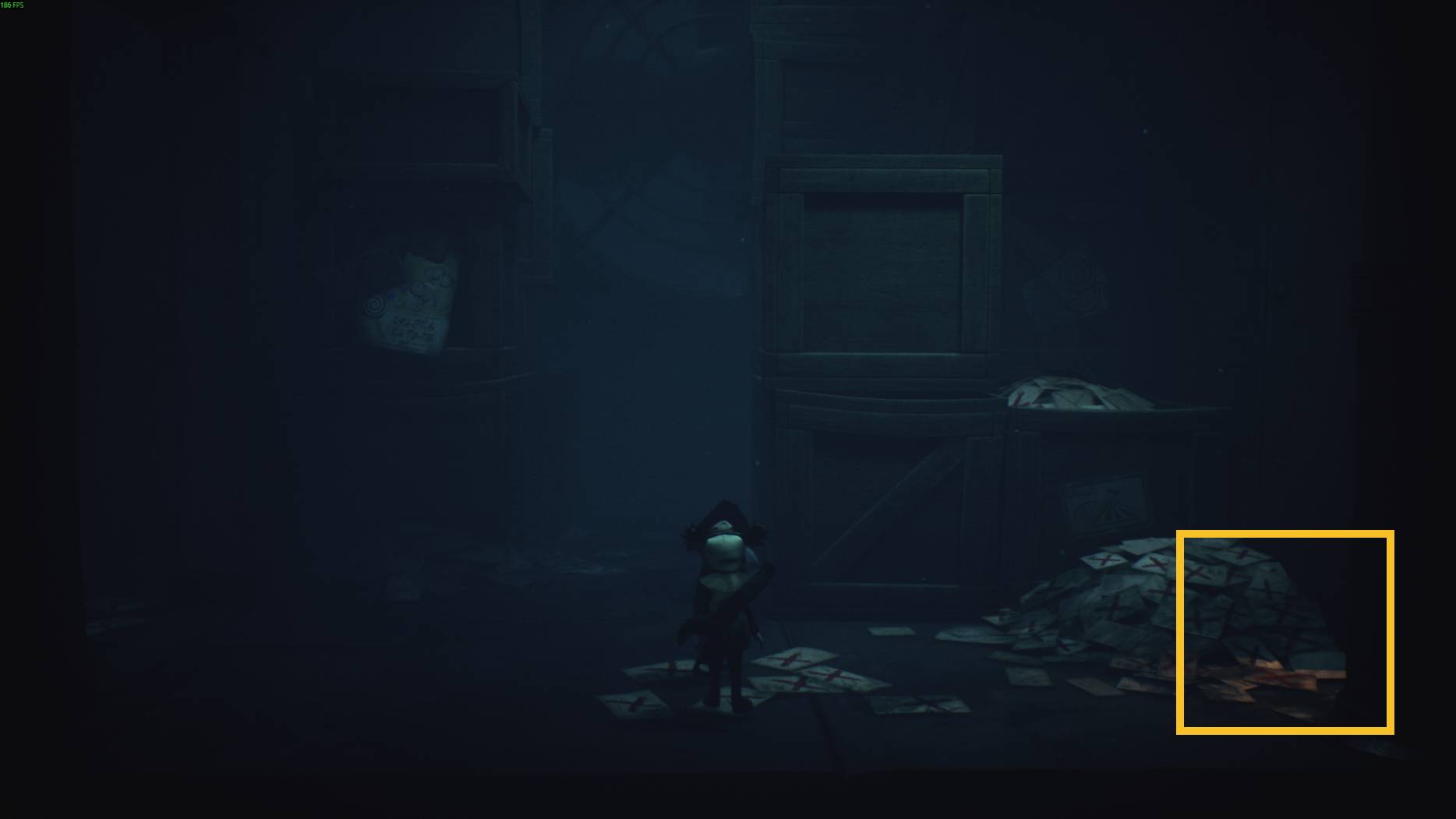 A small hidden figure in Little Nightmares 3 sits among piles of letters and large wooden crates