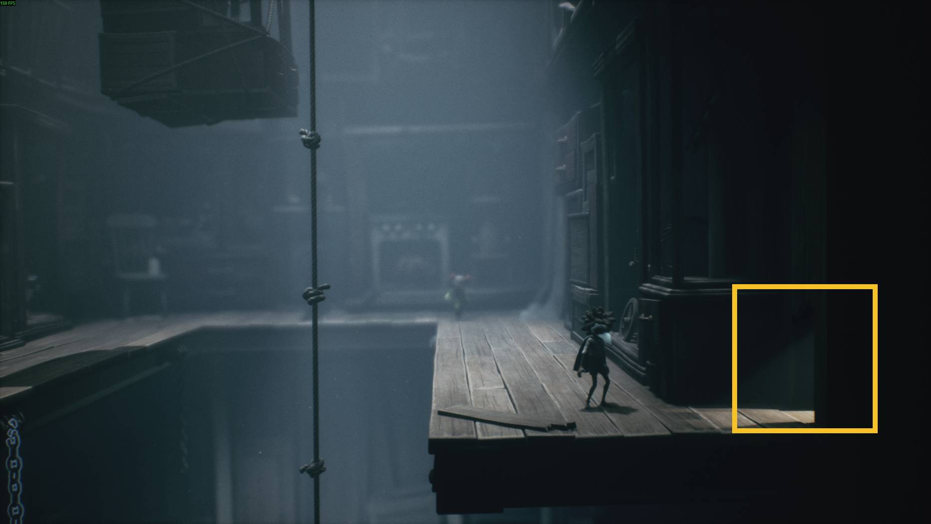Two small characters prepare to cross a rope bridge between wooden platforms in a shadowy room of Little Nightmares 3.