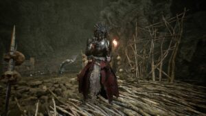 A woman is standing in a cave with a torch, pondering how to increase her ammo supply.