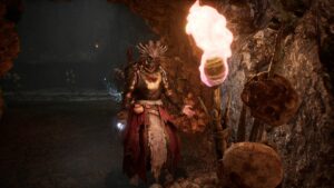 A woman in a costume is standing in a cave, holding a torch illuminated by the best inferno catalyst.