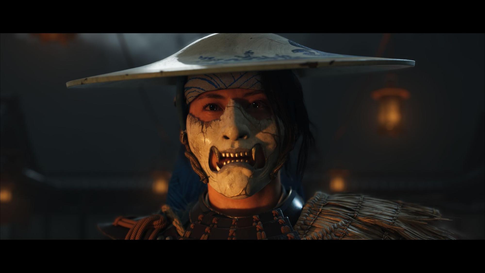 A close-up of a samurai wearing a cracked white oni mask and straw armor in Ghost of Yotei, lit by warm lantern light.
