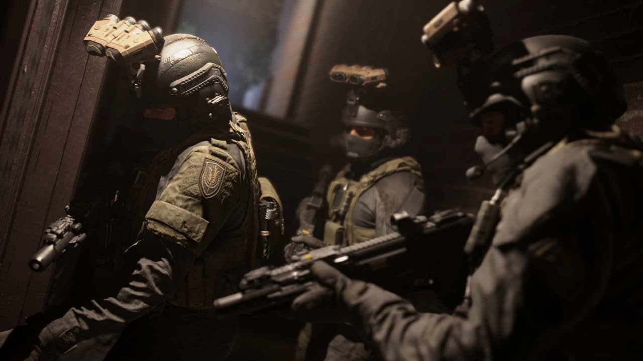 Special forces team in tactical gear preparing to breach a building, holding weapons, illuminated by dim light filtering through smoke in the visually stunning game MW 2019.