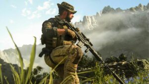 A soldier with a rifle standing proudly in front of a majestic mountain range.