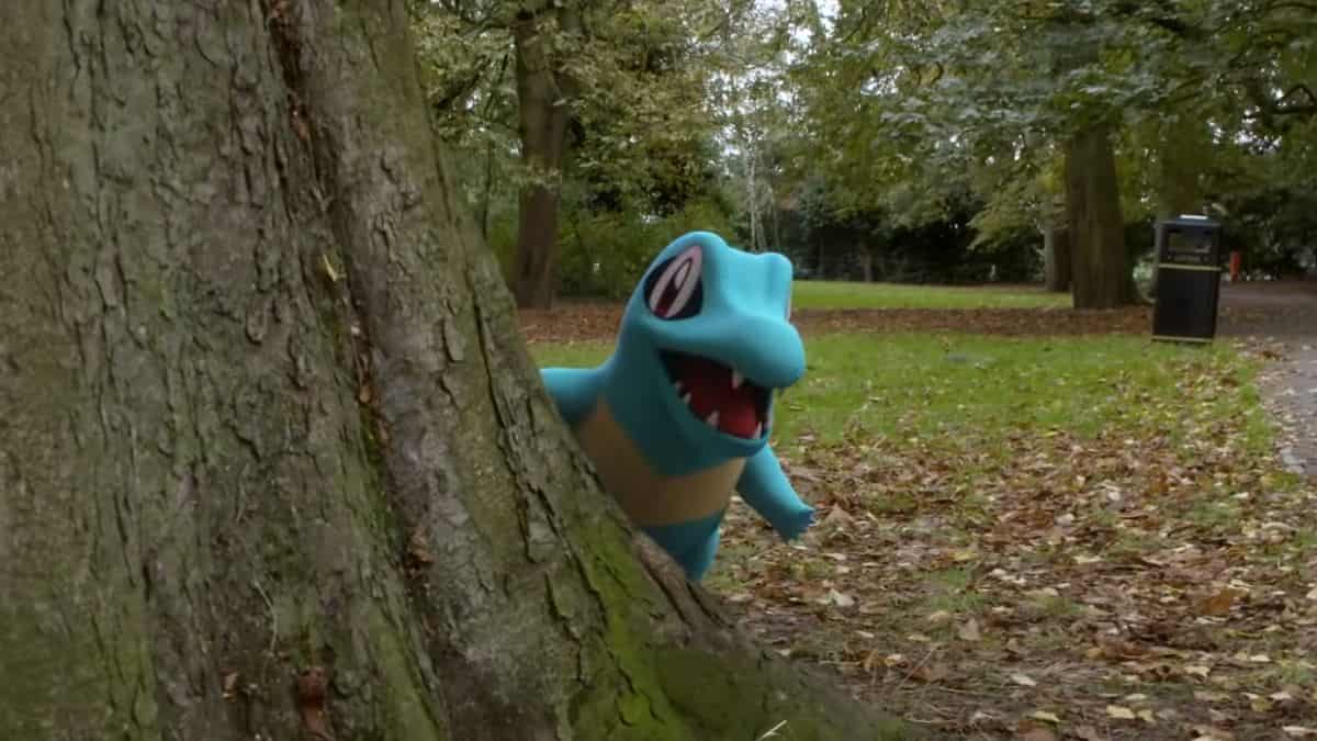 During the Pokemon Go Community Day, a blue Pokemon is hiding behind a tree in a park.