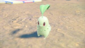 Pokemon-Scarlet-Violet-Indigo-Disk-Catch-Chikorita-Pokemon-Standing-On-Dirt-Path