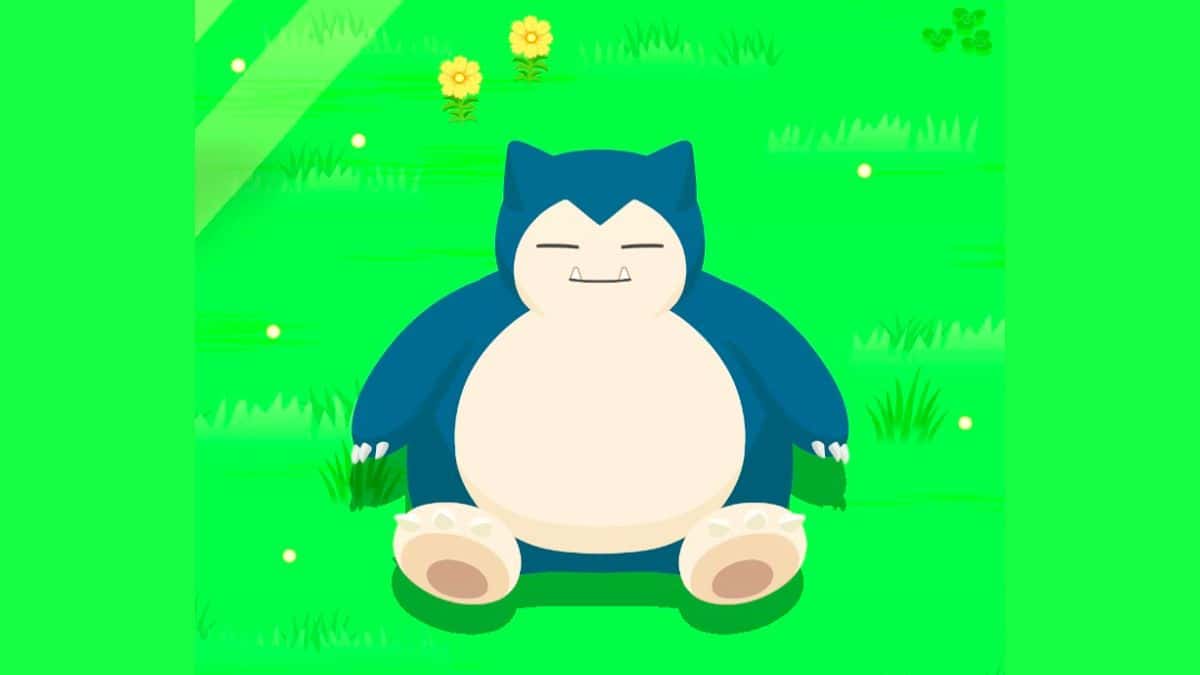 A blue and white cat sitting in the grass, peacefully.