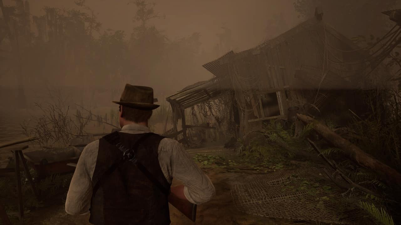 Man in a vest and hat looks alone towards a dilapidated wooden shack in a foggy swamp.