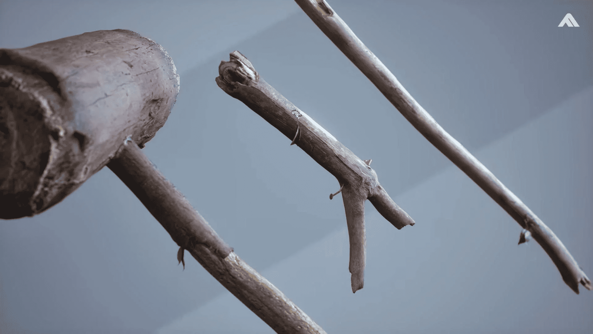 A close-up view of wooden sticks or branches arranged diagonally across a gray background, showcasing the Finals devs' lean into their studio name with the "best skins ever".