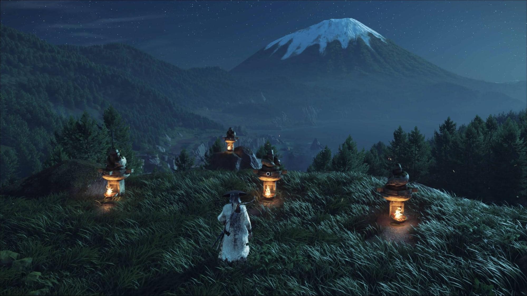 A figure in traditional attire stands among glowing lanterns on a grassy hill at night in Ghost of Yotei