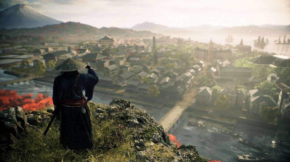 A person dressed in traditional attire stands on a hill overlooking an ancient village in Rise of the Ronin