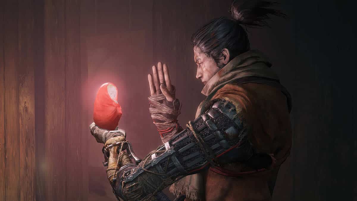 A character with a prosthetic arm examines a glowing statute in Sekiro