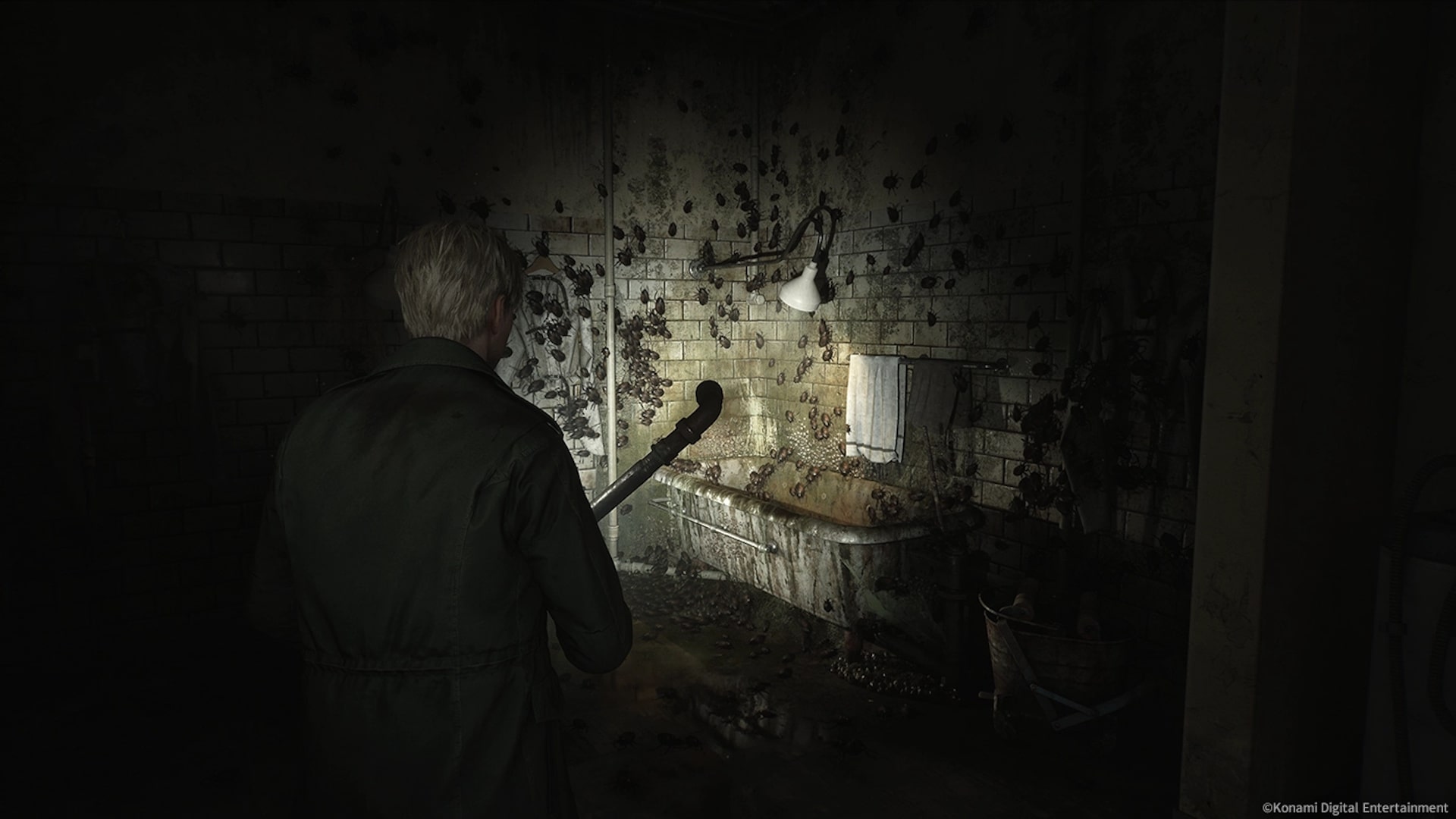 James Sunderland investigates a grimy bathroom covered in cockroaches in Silent Hill 2 remake.