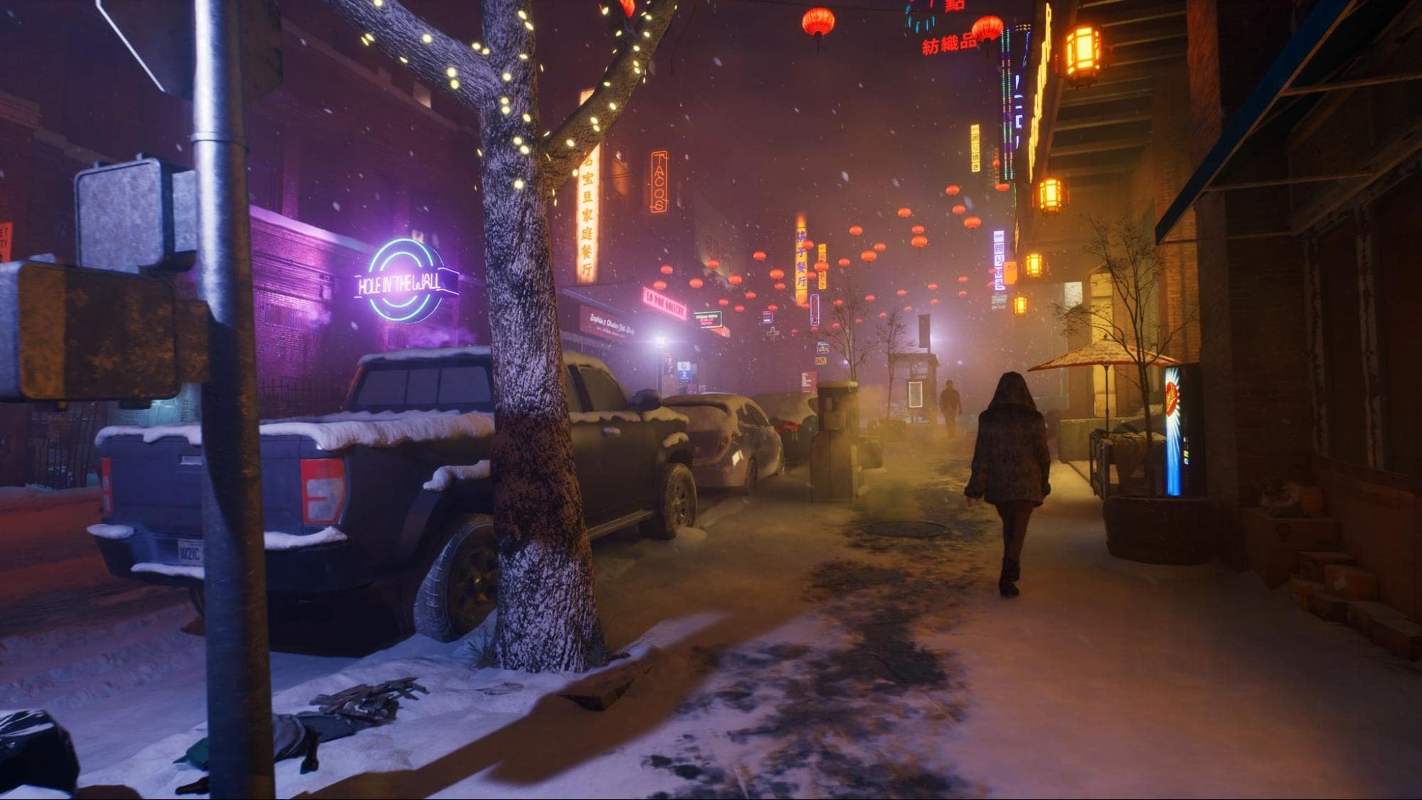 A snowy street scene in Vampire The Masquerade - Bloodlines 2, lit by neon signs and lanterns. Cars line the curb while a lone figure walks away in the distance, adding to the game’s moody atmosphere