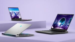 Three laptops - the Alienware X16 R2 - are sitting on a purple surface, showcasing their specs.