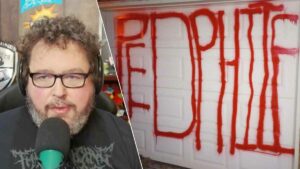A man is holding a microphone in front of a door allegedly vandalized by a local shaman over MTG cards.