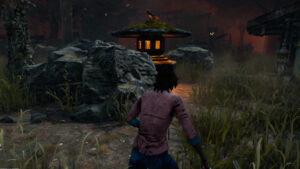 Dead by Daylight best perks for Survivors: An injured survivor runs past an ancient stone lantern while carrying a toolbox.