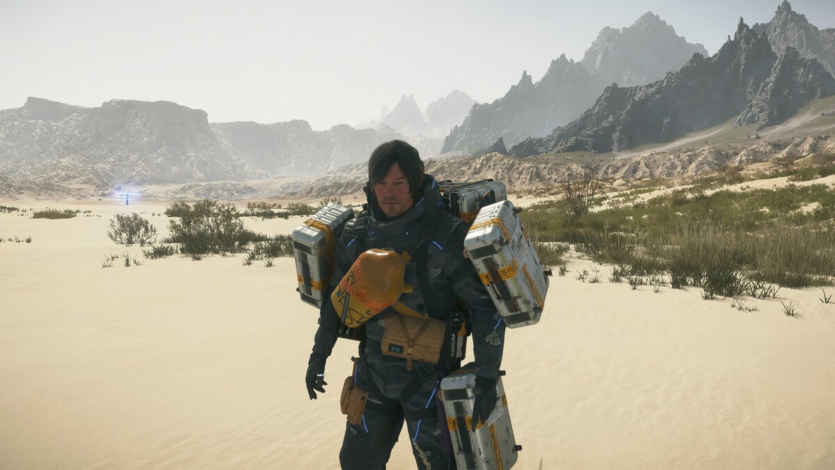 Death Stranding 2 healing blood bags: Sam in a desert with mountains in the background.