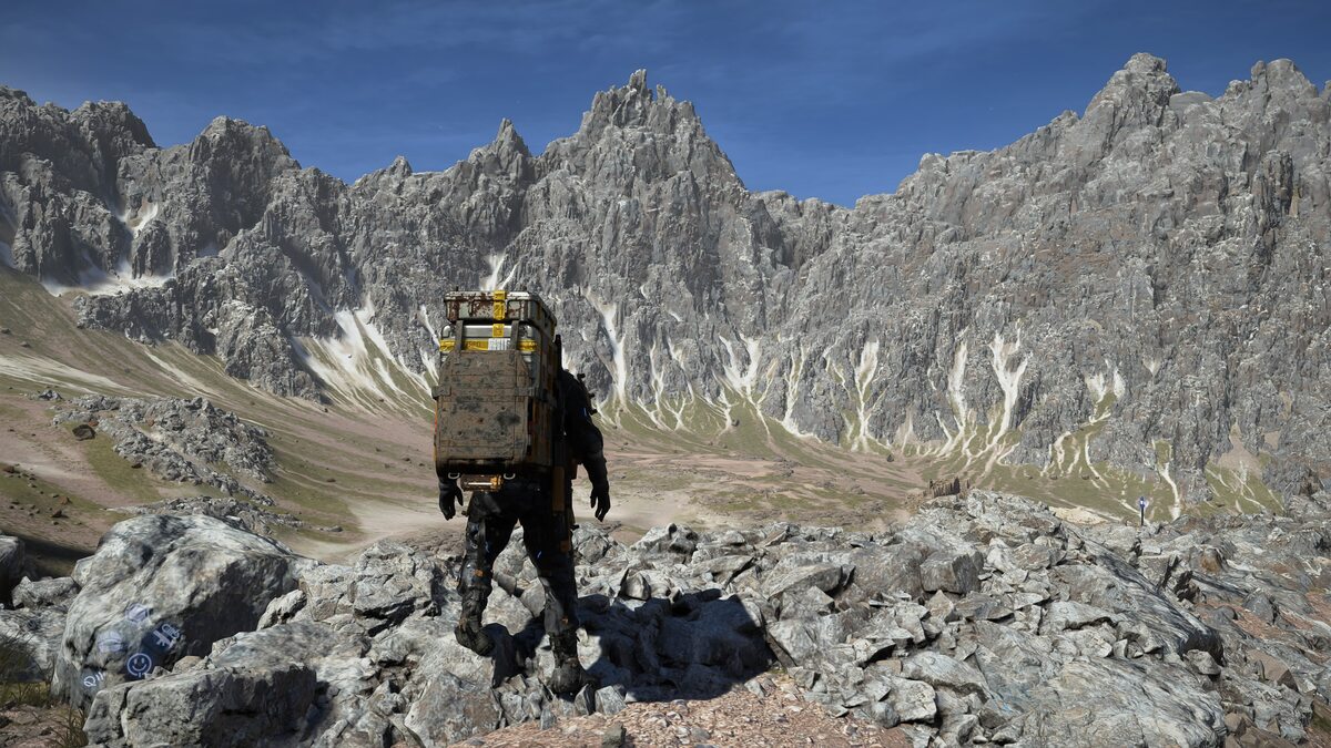 Death Stranding 2 review: Sam below a mountain range.