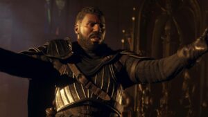 A man in medieval armor gestures dramatically in a dimly lit setting, evoking anticipation for the next Dragon's Dogma 2 patch.