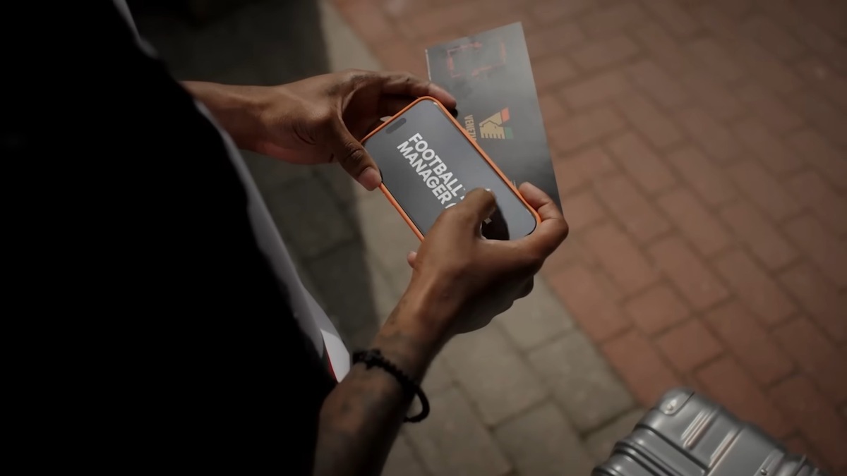 FM25 rollout has been a catastrophe: A phone with a Football Manager title screen in a man's hands.