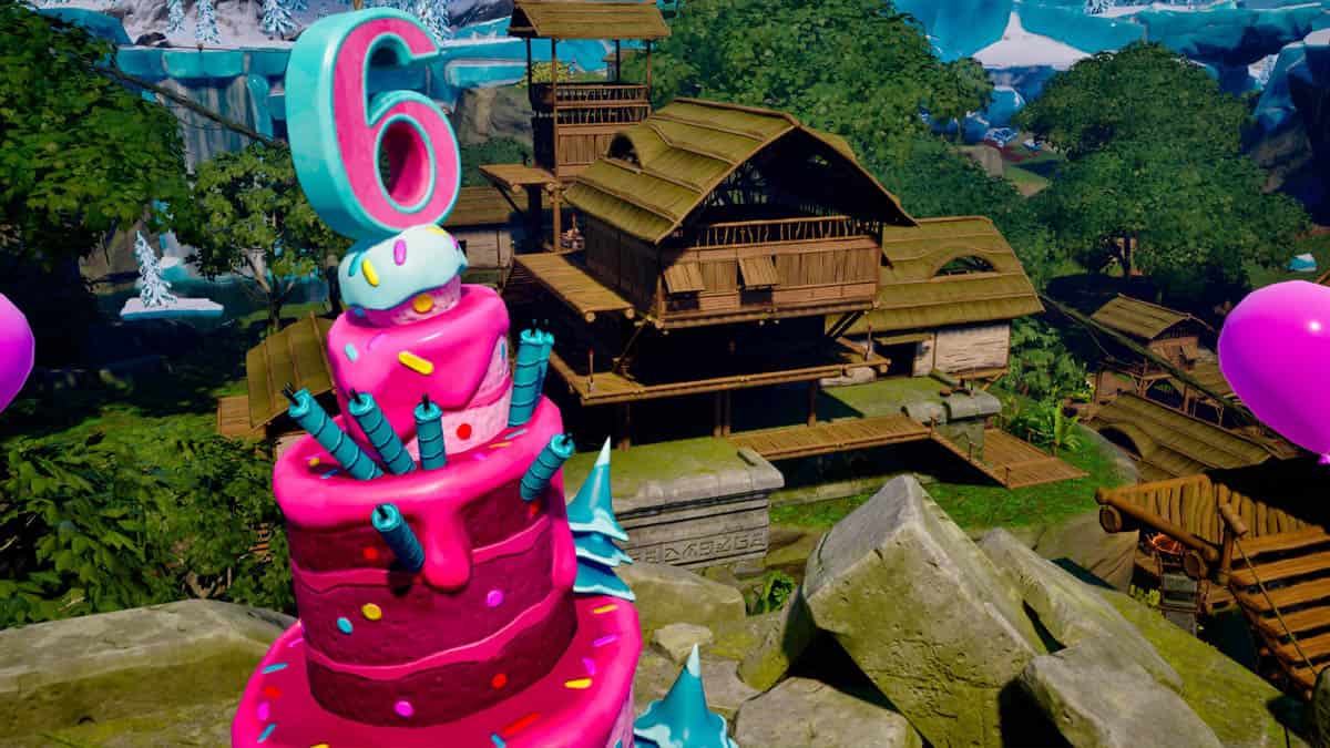 A birthday cake with Fortnite balloons on top of it.